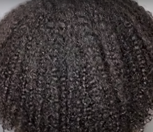 Close-up of textured dark brown hair on a gray background