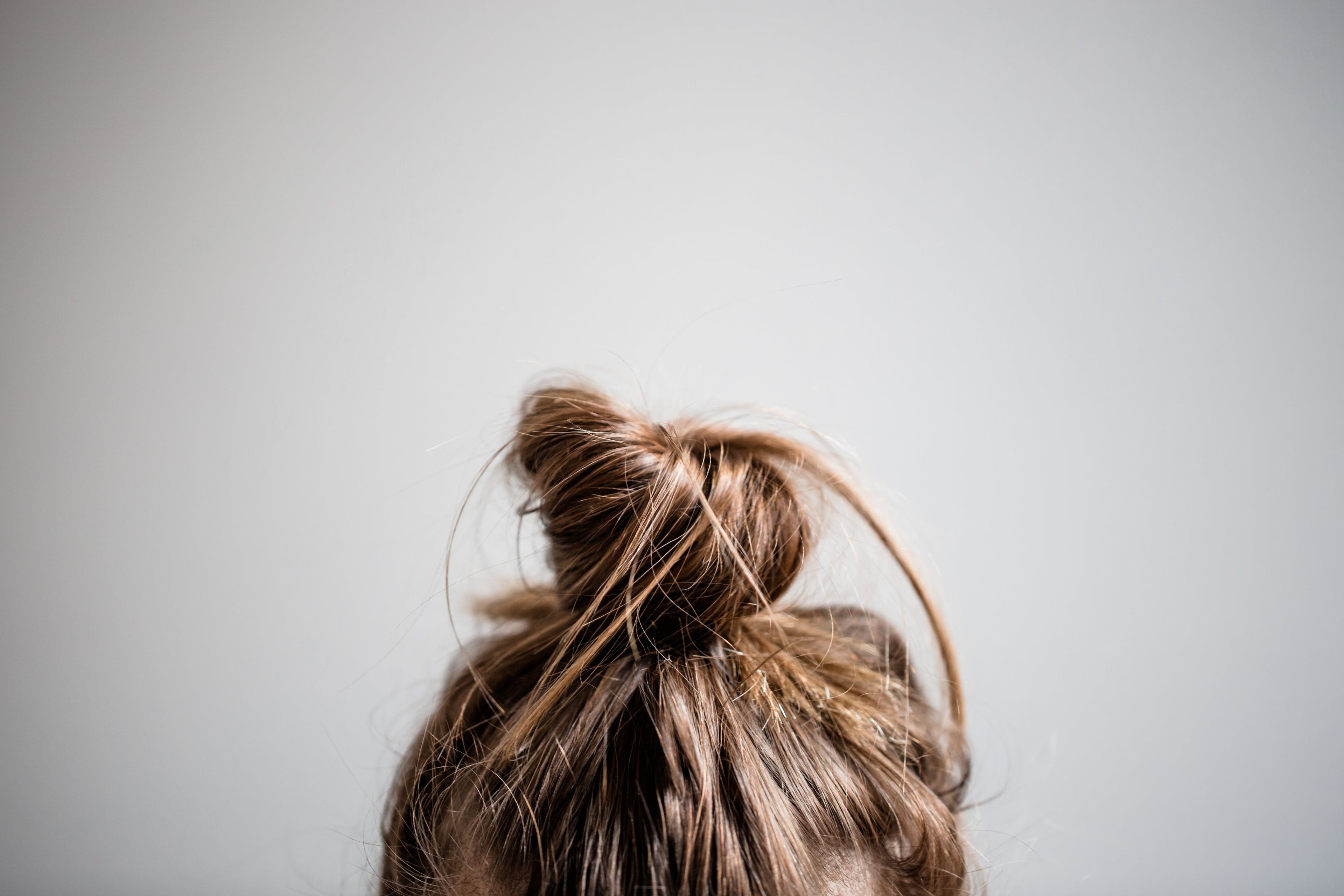 a picture of a high bun hair style on a grey background
