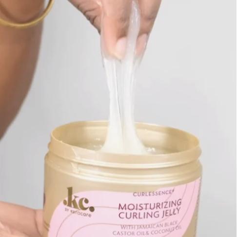 Image of a woman's hand dipped into a cub of curling cream jelly for hair showcasing the consistency of product