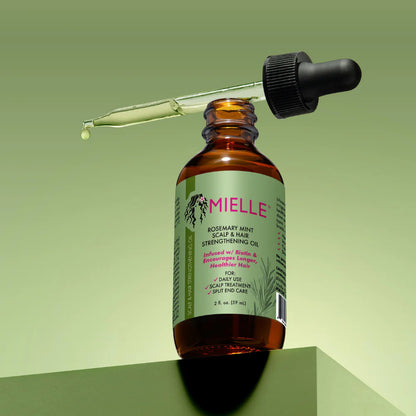 Mielle oil bottle with dropper on a green background