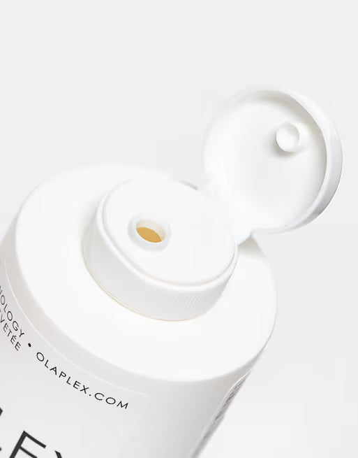 Close-up of a white Olaplex product with a focus on the cap and branding.