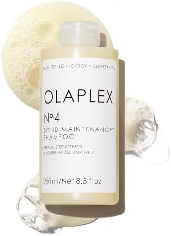 Olaplex No.4 Bond Maintenance Shampoo bottle with a soap bar and water droplets on a white background