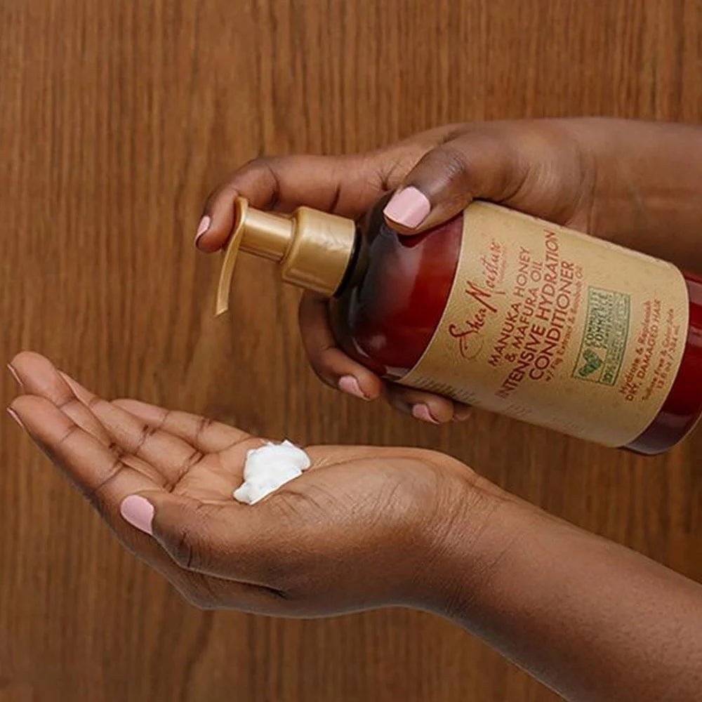 Hand holding a bottle of conditioner with a small amount on another hand against a wooden background