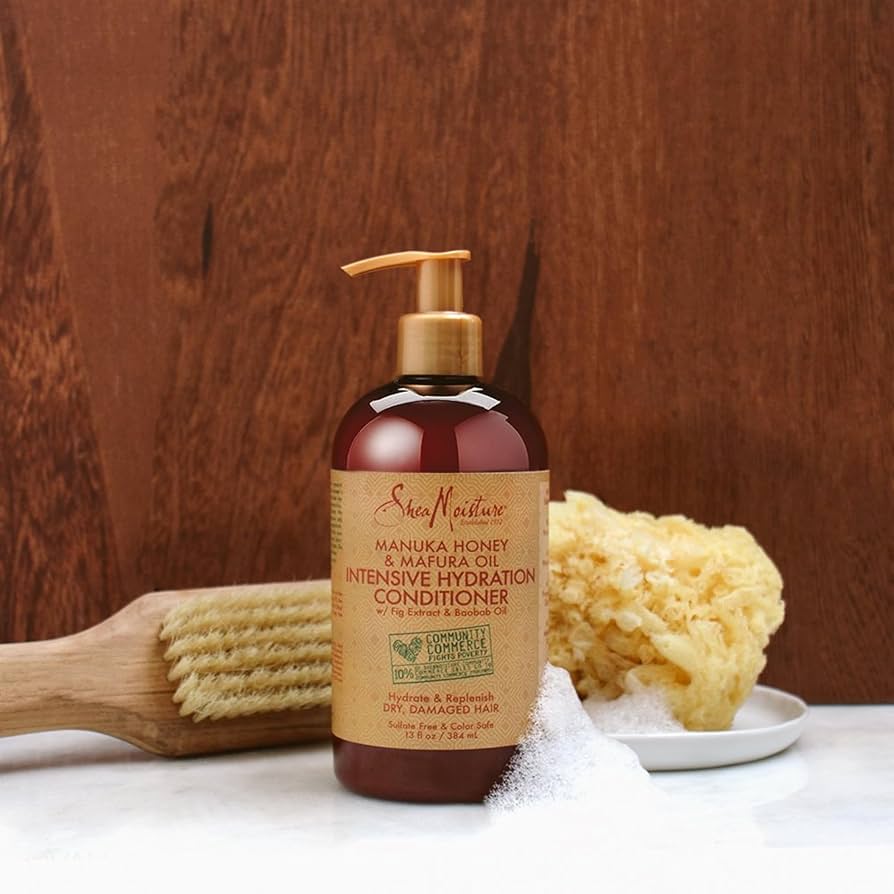 SheaMoisture conditioner bottle with a wooden brush and sponge on a wooden background
