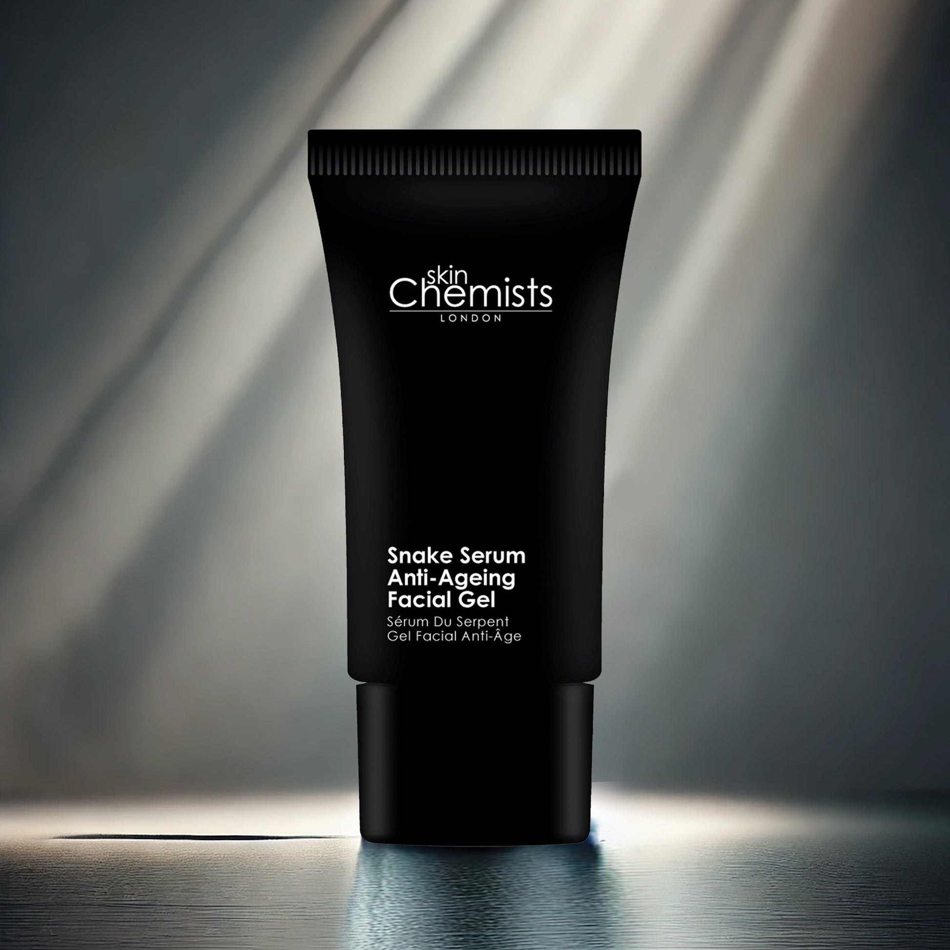 Black tube of 'skinChemists London' Snake Serum Anti-Ageing Facial Gel on a reflective surface with a blurred background