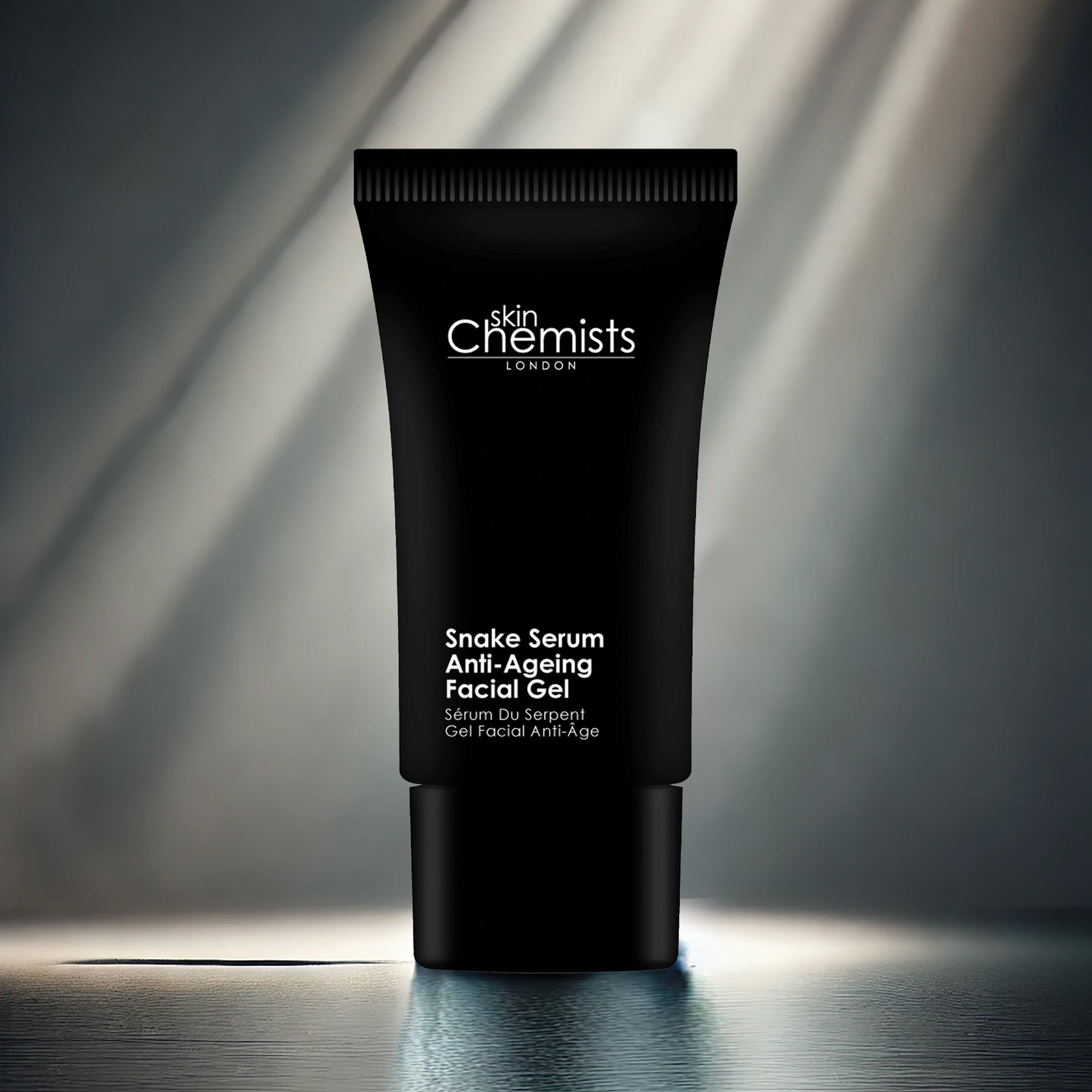 Black tube of 'skinChemists London' Snake Serum Anti-Ageing Facial Gel on a reflective surface with a blurred background