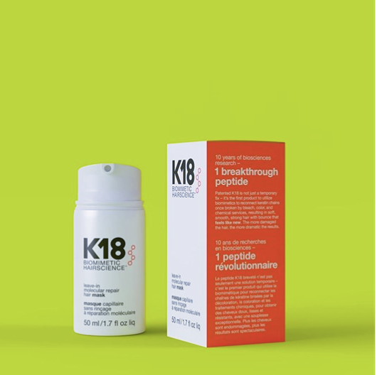 K18 hair mask bottle and packaging on a green background