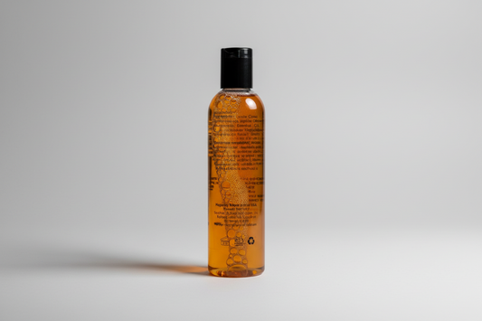 Bottle of brown liquid with bubbles on a textured white surface