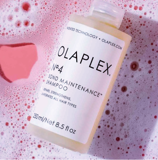 Olaplex shampoo bottle with a pink bubble background