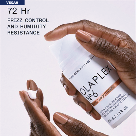 Olaplex hair treatment product with hands holding it on a beige background