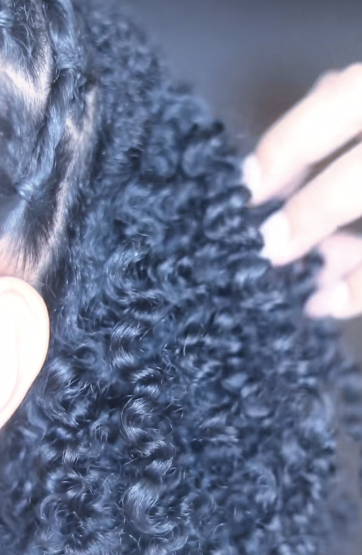 Close-up of curly black hair being held with hands