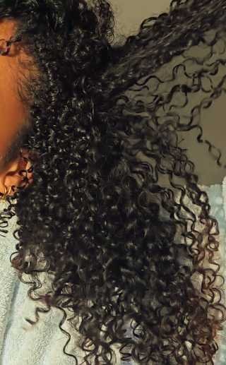 Close-up of a person with curly hair on a neutral background