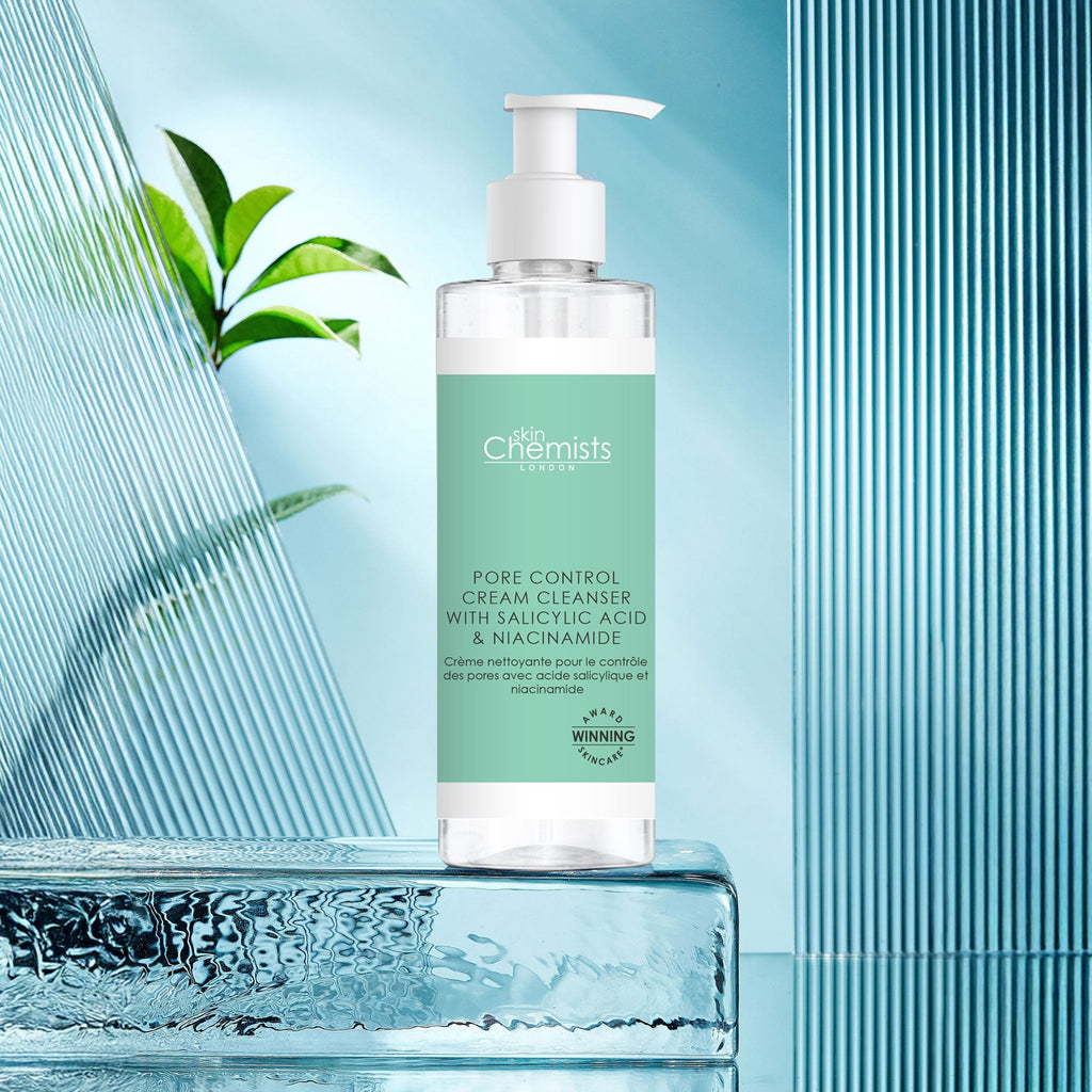 Bottle of 'The Chemists' Pore Control Cream Cleanser with Salicylic Acid & Niacinamide on a blue background