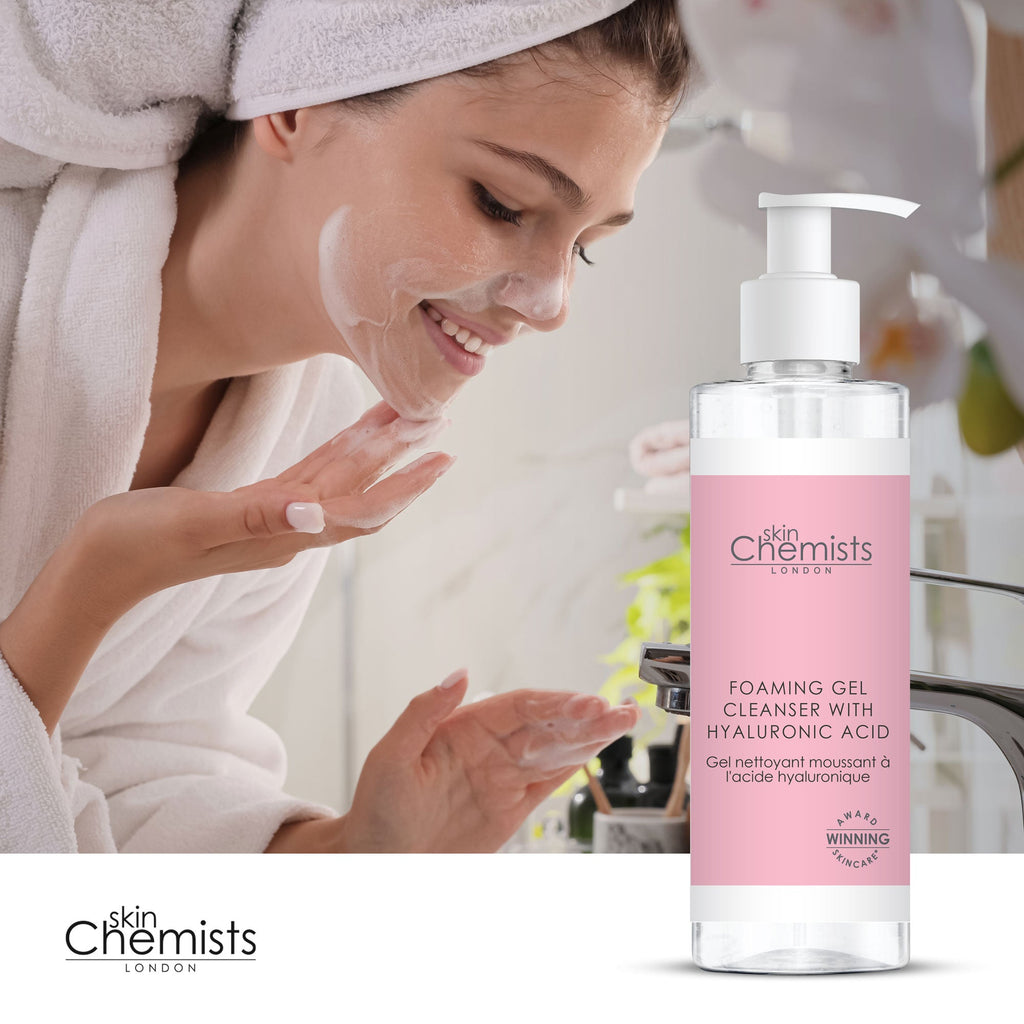 Woman applying skincare product with a bottle of 'skin Chemists' Foaming Gel Cleanser.