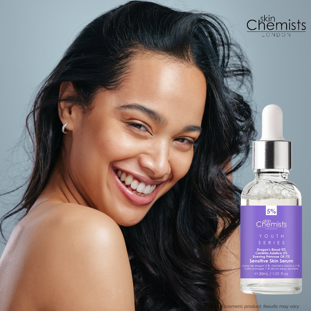 Woman with a radiant smile next to a bottle of 'skin Chemists' serum on a gray background